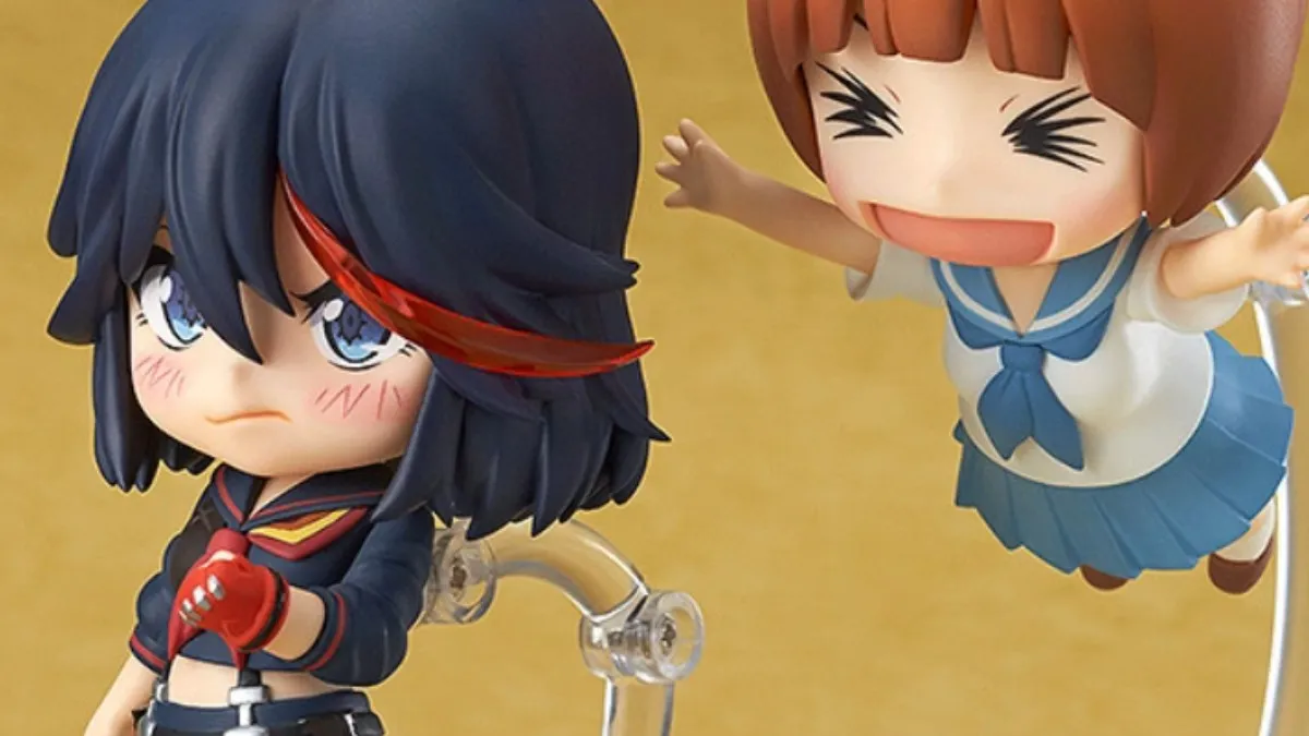 A Nendoroid of Mako leaps into the air to excitedly tackle an annoyed-looking Ryuko.